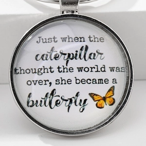 Creative silver metal butterfly pendant keychain with inspirational quote on white background