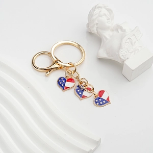 Close-up of golden heart keychains with American flag enamel pattern on white tray