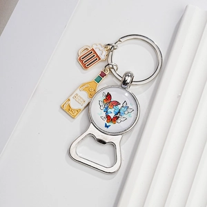 Detail of vintage beer bottle opener keychain with colorful butterfly glass cabochon