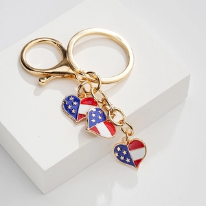 Detail of American flag heart charms on a golden metal keychain with lobster clasp