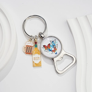 Close-up of silver metal beer bottle opener keychain with butterfly charm and beer glass charm