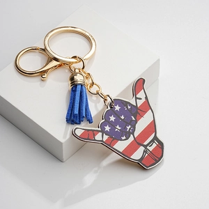 Porte-clés signe Shaka drapeau américain avec quincaillerie dorée et pompon en daim bleu