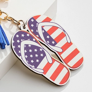 Porte-clés tong en bois avec motif drapeau américain et pompon bleu sur socle blanc