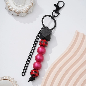 Detail of beaded keychain with pink beads and buffalo plaid wooden beads on black hardware