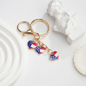 Detail of gold metal keychain with American flag heart charms and lobster clasp