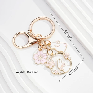 Detailed view of cute rabbit keychain with cherry blossom charms and size measurements