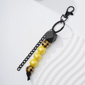 Detailed macro view of geometric wooden beads and black metal chain on a stylish keychain