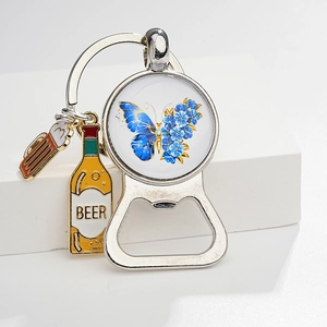 Detail of vintage butterfly bottle opener keychain with miniature beer mug and bottle charms