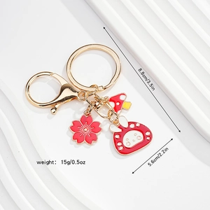 Detailed view of enamel bunny keychain with cherry blossom and mushroom pendants