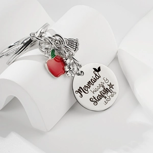 Vue détaillée du porte-clés pour enseignant avec charms de pomme rouge et queue de poisson