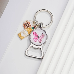 Macro detail of silver bottle opener keychain with beer bottle and butterfly charms