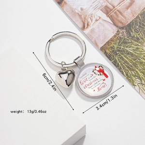 Détail d'un porte-clés oiseau cardinal rouge avec breloque cœur et pendentif commémoratif