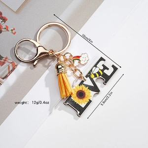 Detail view of LOVE keychain with sunflower, yellow tassel and size dimensions shown