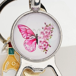 Close-up of butterfly and sakura pattern on vintage metal bottle opener keychain charm