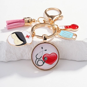 Détail du porte-clés infirmier avec figurine, thermomètre, masque et pompon rose