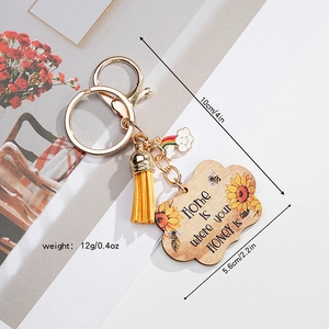 Detail of sunflower bee keychain with wooden cloud charm and a yellow tassel pendant
