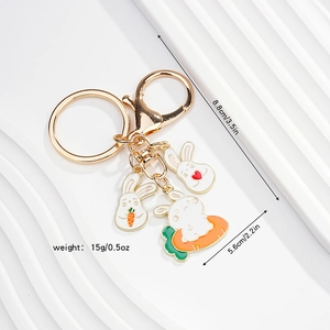 Detailed size and weight specs of a golden metal rabbit keychain with enamel charms