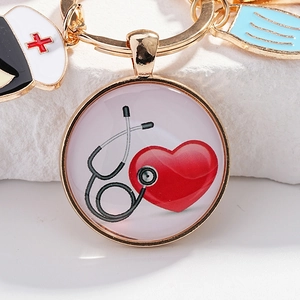Porte-clés infirmière doré avec bonnet à croix rouge, masque bleu et charme cœur stéthoscope