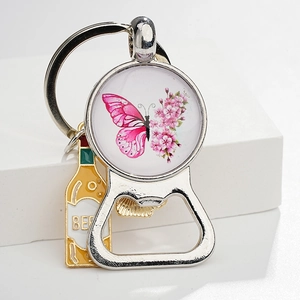 Detail view of butterfly glass gem bottle opener keychain with a mini beer bottle charm