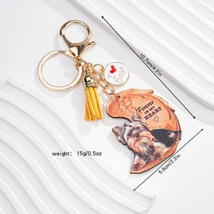 Detail of Yorkshire Terrier keychain with gold lobster clasp, yellow tassel and heart quote