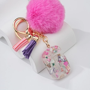 Porte-clés pompon rose avec lettre G en résine transparente remplie de pierres colorées