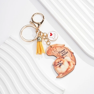 Close-up of golden dog keychain with yellow tassel and heart-shaped memorial photo pendant