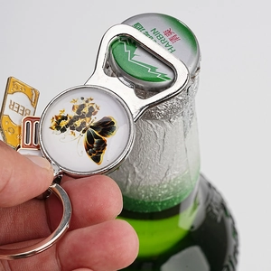 Close-up of metal bottle opener keychain with butterfly art and yellow beer charm