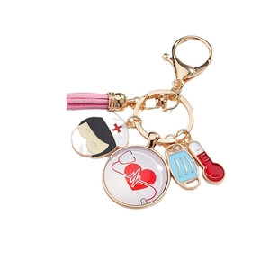 Porte-clés infirmière avec badge battement de coeur et pompon rose sur anneau doré