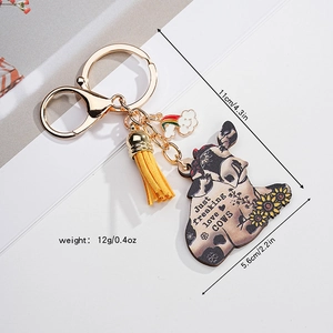 Detail view of sunflower cow acrylic keychain with yellow tassel and rainbow charm