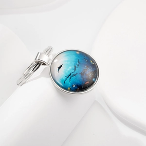 Polished silver keychain with a clear glass dome featuring a vibrant blue ocean dolphin scene