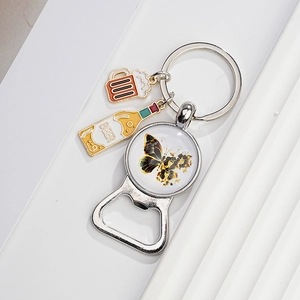 Detail of metal beer opener keychain with colorful butterfly gem and enamel beer charms