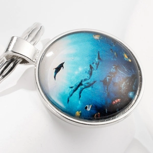 Marine dolphin theme time gem keychain with silver metal pendant on white background