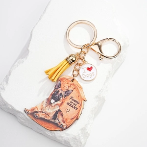 Macro detail of German Shepherd acrylic keychain with gold lobster clasp and yellow tassel