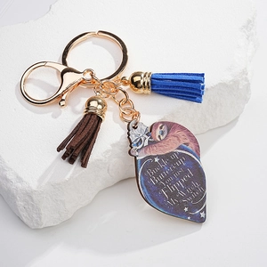 Detail of sunflower sloth acrylic keychain with blue tassel and gold metal lobster clasp