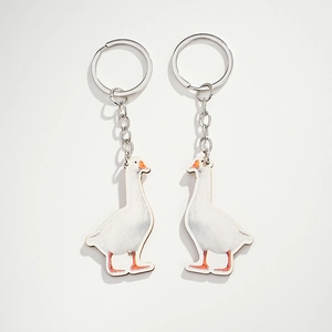 Close-up of the realistic white goose wood keychain set with silver rings and metal chains