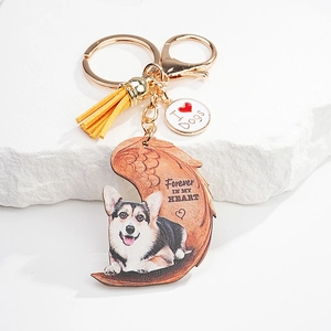 Detail of dog memorial keychain featuring Corgi print, angel wings, and yellow tassel