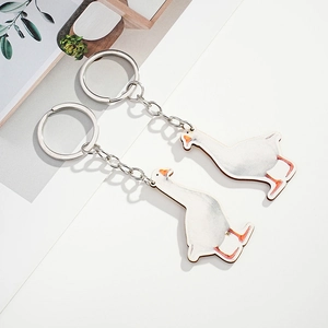 Detail of two white goose keychains with orange beak and stainless steel rings
