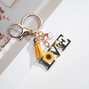 Detail of sunflower keychain set with yellow tassel and colorful enamel rainbow pendant