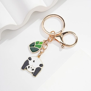 Detailed close-up of gold metal panda keychain with green leaf enamel charm pendant