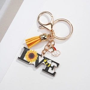 Detailed view of sunflower LOVE keychain with yellow tassel and rainbow cloud pendant