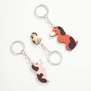 Detailed view of three cute cartoon wooden dog keychains with metal rings and chains