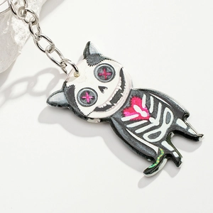 Detailed close-up of a gothic skeleton cat keychain with pink hearts and silver metal ring
