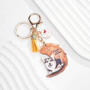 Detail of corgi dog keychain with yellow tassel and crescent moon wood pendant