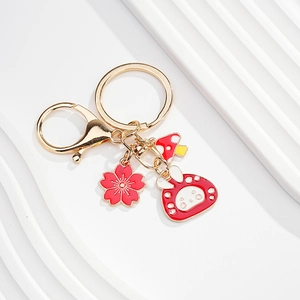 Detail of a golden metal keychain with cherry blossom, mushroom, and cute rabbit charms