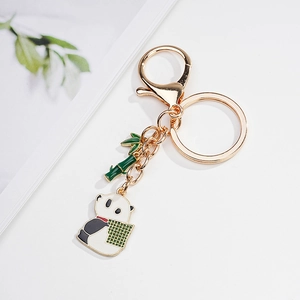 Close-up of golden metal panda keychain with green bamboo pendant and lobster clasp detail