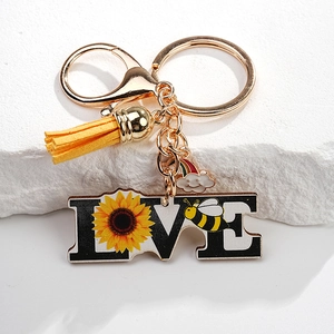 Detail of sunflower bee LOVE keychain with gold ring and yellow faux leather tassel
