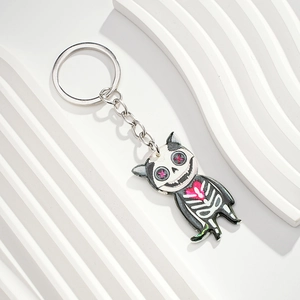 Macro shot of skull cat keychain with pink heart eyes on white textured background