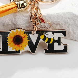 Detail of sunflower and bee acrylic pendant with yellow tassel and rainbow charm