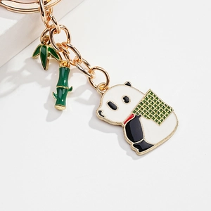 Detailed close-up of cute panda metal keychain with green bamboo leaves and stalks