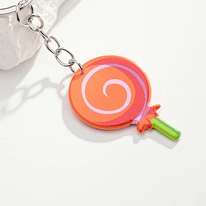 Detail of creative lollipop keychain with orange spiral pattern and green stick
